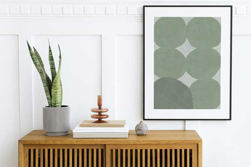 Picture frame mockup hanging above wooden cabinet