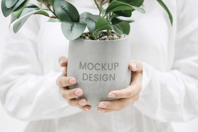Woman holding a gray plant pot mockup