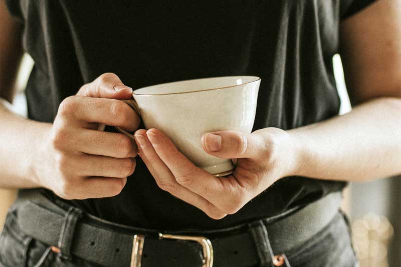 Woman with a tea cup mockup in her hands psd